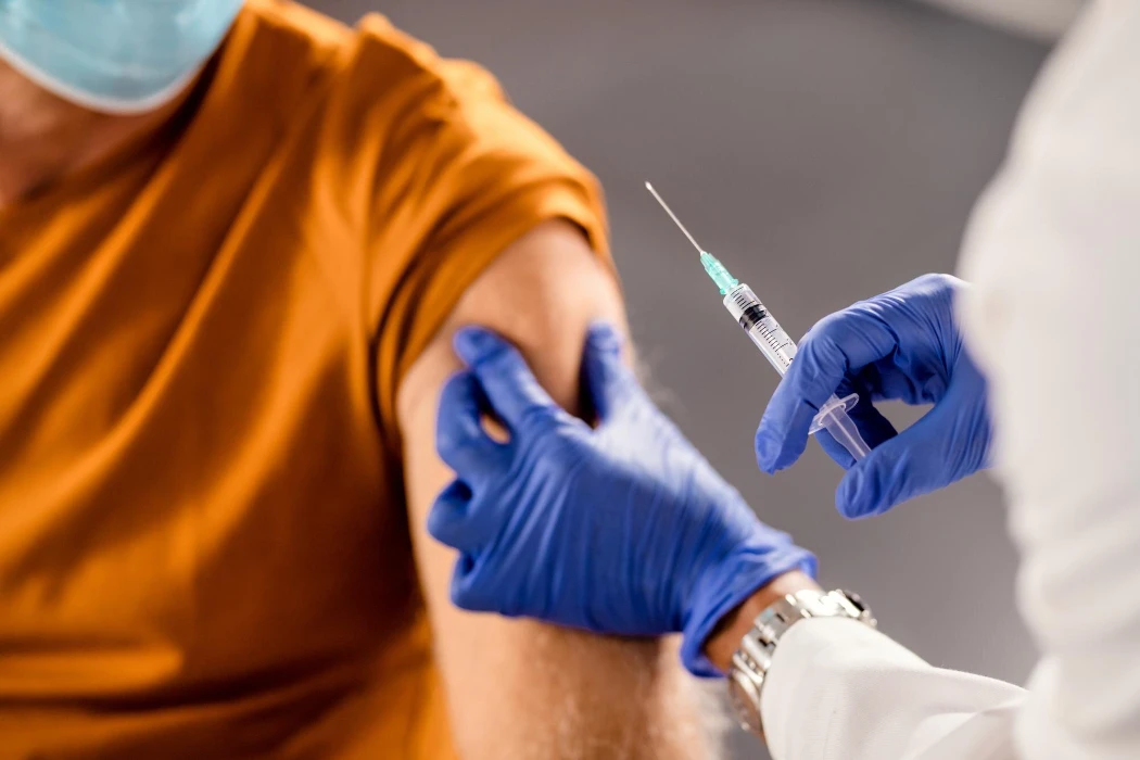 Closeup of healthcare worker giving a vaccine to senior patient